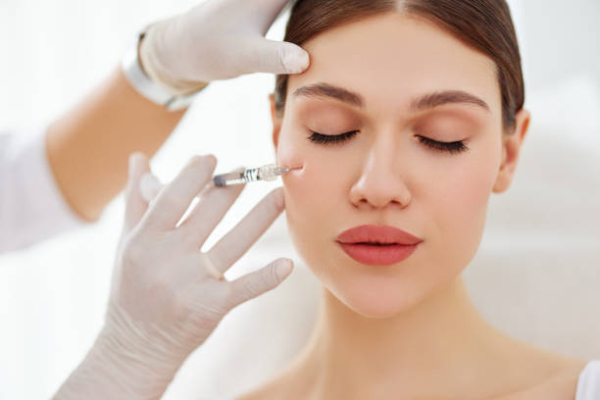 Young female patient getting injection to cheekbone Image